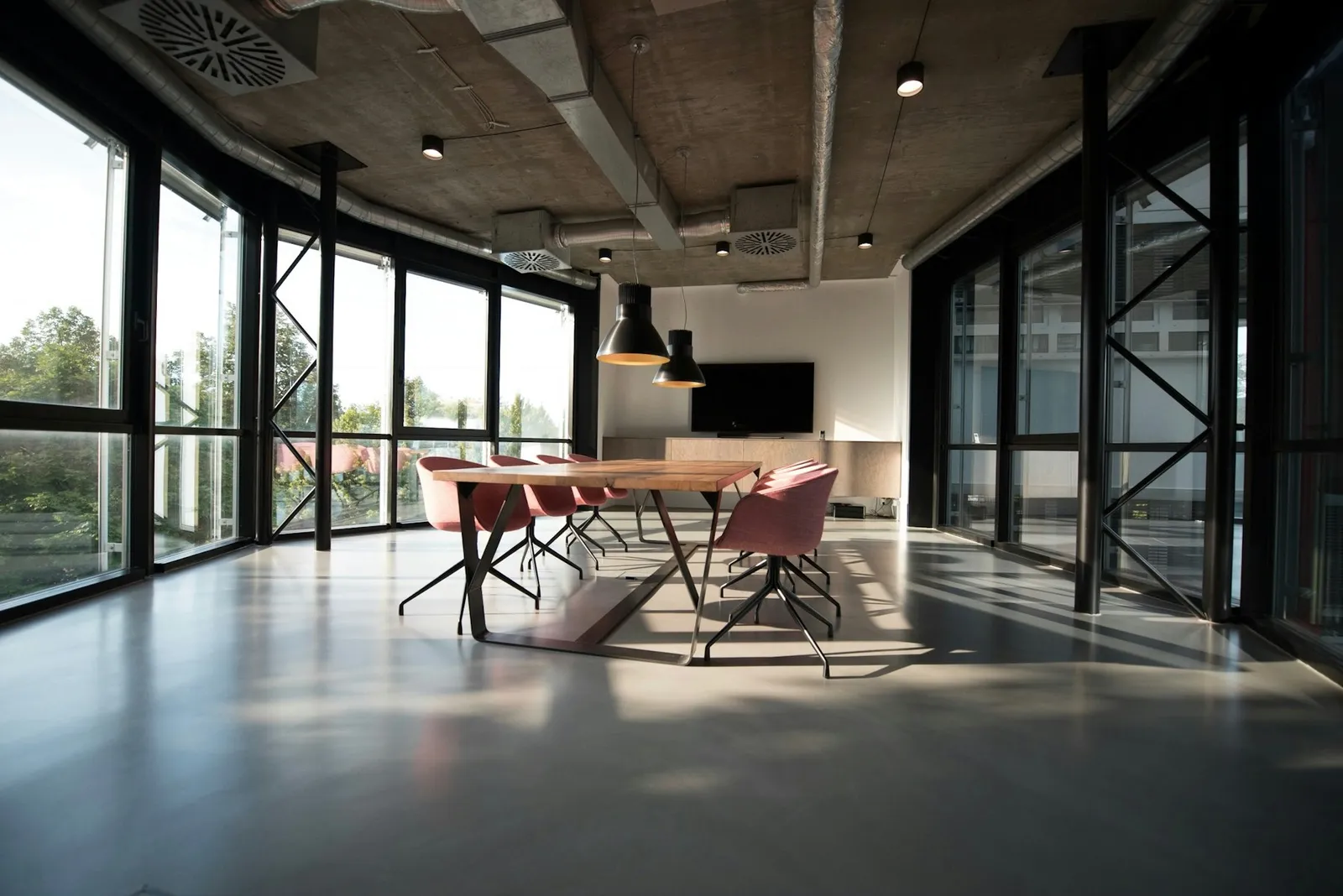 Daylit contemporary workspace with long shared tables; illustrative, not a company project or team